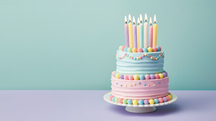 Colorful birthday cake in pastel colors with birthday candles and turquoise background