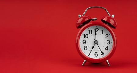 Red alarm clock on a red background.