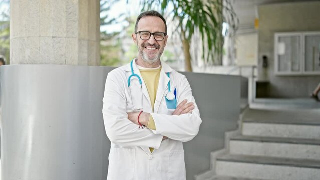 Middle age man doctor smiling confident standing at hospital