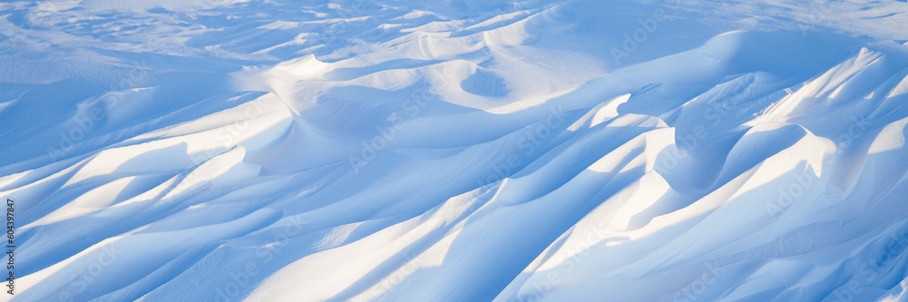 Wall mural snow texture. wind sculpted patterns on snow surface. wind in the tundra and in the mountains on the