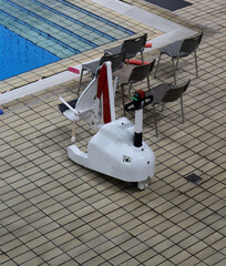 Μobile seated chair lift that allows effortless entry into a swimming pool for disable people