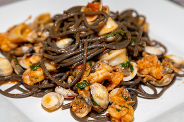 Black spaghetti with sepia squid ink with seafood, clams and shells. Nero di seppia