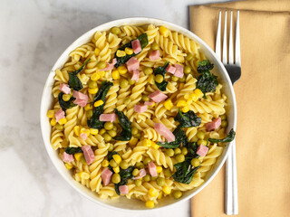 rotini pasta  with corn peas and dhan with sauteed spinach,