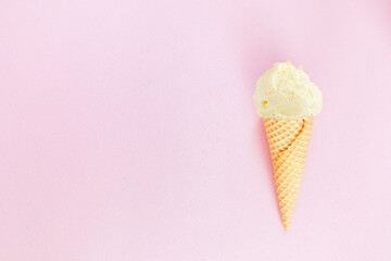 Single ice cream cone with vanilla ice cream over a textured pink background. Top view with copy...