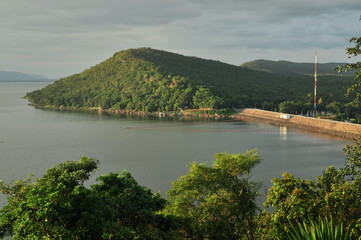 Fototapeta premium Overview of Ubonrat Dam, famous Dam in northeast of Thailand, mountain and green scene, tree at foreground
