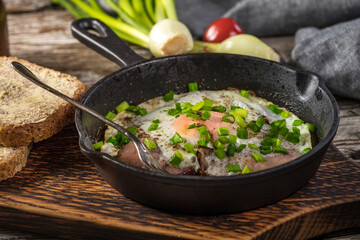 Fried eggs with ham on an old wooden background.