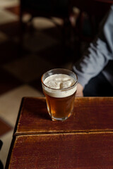 Pint of beer on wooden table in the bar