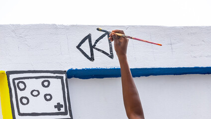 A dedicated young artist engaging with the community as they paint a collaborative mural, fostering a sense of unity and pride in the neighborhood.