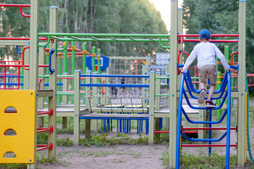 The boy is playing on the playground. Playground for active children's games