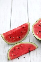 Two slices of watermelon, tower, black seeds, on a white wooden table, hello summer, vitamins, photo background, background, wallpaper