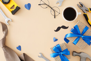 Stylish gift concept for Father's Day. Top view flat lay of gift boxes, coffee, mustache, glasses, hand tools and blue hearts on light beige background with empty space for text or advert