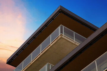building with balcony corner on dramatic sky clouds sunset minimalist architecture