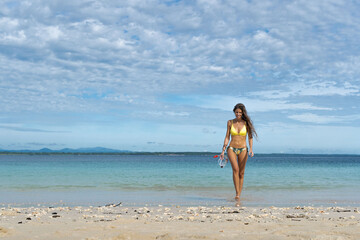 Fototapeta na wymiar Sexy bikini body blonde woman on paradise wild tropical beach. Travel vacation