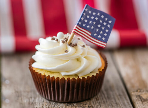 Cupcakes with red-white-and-blue frosting and American flags on . Happy Fourth of July celebration cake. ai Generative
