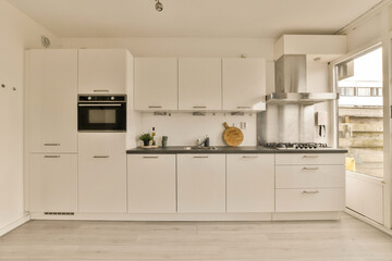 a kitchen with white cabinets and black counter tops on the island in front of the sink is an oven,...