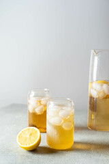 Black tea with ice and lemon in a tall glass. Cold lemonade. 