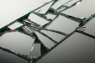 Shards of broken mirror on backing board, closeup
