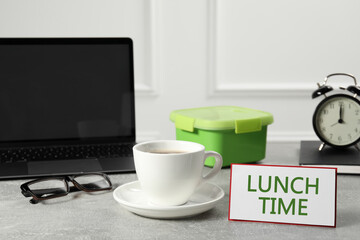 Business lunch time. Workplace with cup of coffee, card and lunch box in office