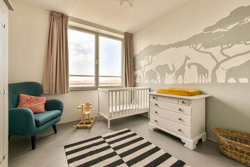 a baby's room with a cribt and an elephant wall mural on the wall in the nursery © Casa imágenes