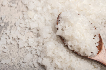 A large grain of sea salt on a gray background.