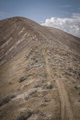 View of narrow ridge line trail in adobe clay badlands in Peach Valley Recreation Area near Montrose Colorado