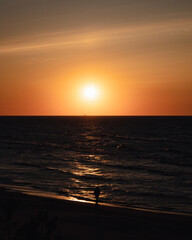 Fototapeta na wymiar sunset on the beach with walking person