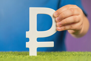 Ruble symbol in hands on a purple background. The concept of the growth or fall of the value of the...