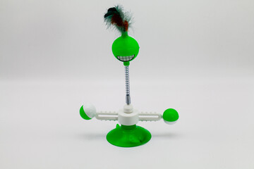 A green cat toy with feathers with white background.