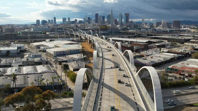 2023 - Excellent aerial footage of cars driving across the 6th Street Viaduct into Los Angeles, California on an overcast day.