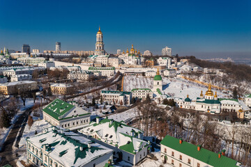 Beautiful winter top view of the Kiev-Pechersk Lavra. Many churches in the snow. Beautiful panorama of Kiev in the afternoon. - 604443488