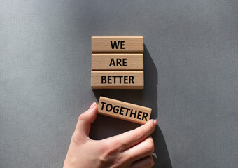 We are stronger together symbol. Wooden blocks with words We are stronger together. Businessman hand. Beautiful grey background. We are stronger together concept. Copy space.
