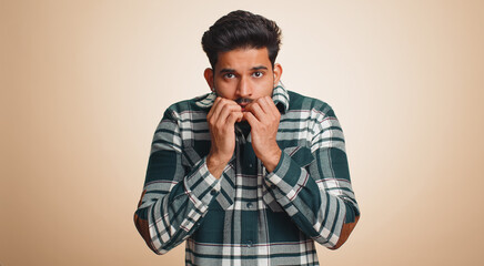 Stressed depressed indian man terrified about danger problems, suffering phobia, anxiety disorder, expresses fear, waving no, insecure, stress, panic. Hindu guy isolated on beige studio background