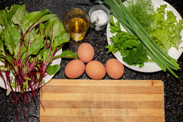 Ingredients for cooking vegetable spring salad. Fresh beet leaves, herbs, eggs, oil and salt on a...