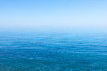 Ocean sky horizon line blends fading into infinity with blue turquoise colors of serene ocean waters and cloudless sky