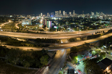 Aerial view of american freeway intersection at night with fast driving cars and trucks in Miami,...