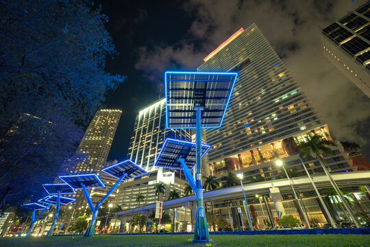 Modern urban street neon illumination with solar photovoltaic panels for power supply of streetlights and surveillance cameras. Futuristic energy source in downtown Miami, Florida