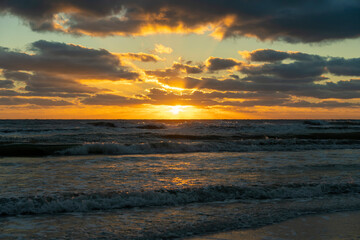 Ocean sunset landscape with soft evening sea water waves crushing on sandy beach