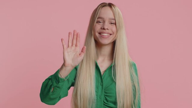 Come here, join us. Welcome. Young woman showing inviting gesture with hands, ask to join, beckoning to coming, gesturing hello, goodbye. Caucasian teenager girl isolated on pink studio background