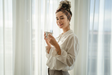 One woman have a cup of coffee at the window at home morning or day