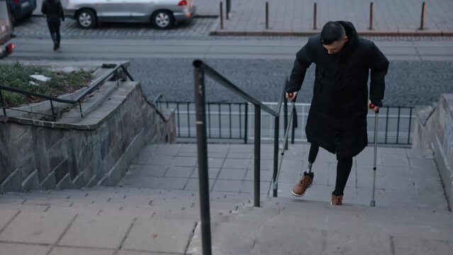 Determined step, Orthotic support, Disabled community. City street has disabled man ascending stairs with aid of prosthetic leg.