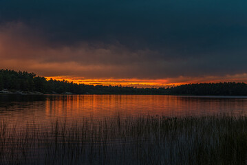 Sunset above forest lake