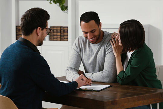 Professional notary working with couple in office