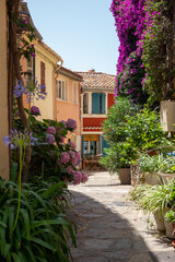Fototapeta na wymiar Ruelle et fenêtre d'une maison provençale à la façade rouge de Bormes-les-Mimosas avec des fleurs d'hortensia au premier plan