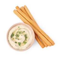 Delicious grissini sticks and hummus isolated on white, top view