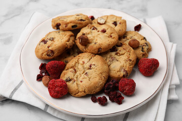 Cookies with freeze dried fruits and nuts on white marble table, closeup