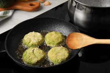 Cooking vegan cutlets in frying pan on stove