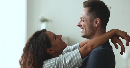 Close up of beautiful enamoured Hispanic couple hugging, dance or slowly moving and laughing enjoy romantic date and flirtation, spend time together on weekend at home. Romance, relationships, love