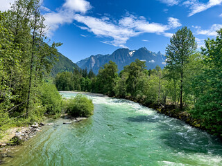 Gem green color Skykomish river with snowcapped cascade mountains in Washington State © tab62