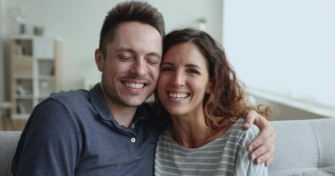 Close up portrait of young loving Hispanic spouses hugging smile staring at camera, posing for family portrait. Romance, relationships and harmonic happy marriage, couple take part in video call event