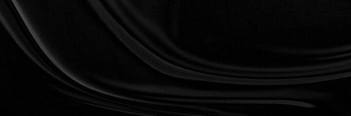 Black gray satin dark fabric texture luxurious shiny that is abstract silk cloth panorama background with patterns soft waves blur beautiful.